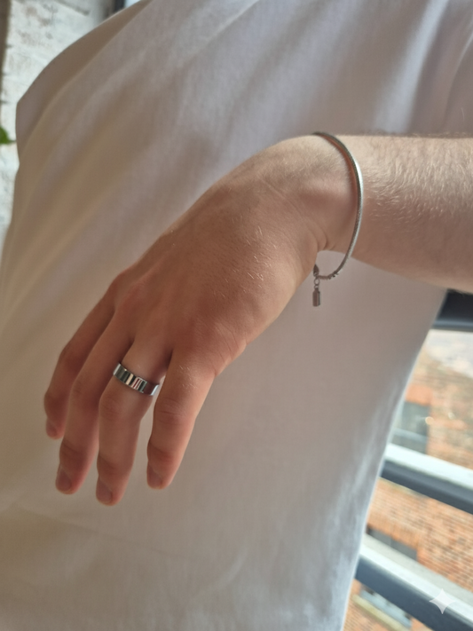 Hand wearing a silver ring and bracelet.